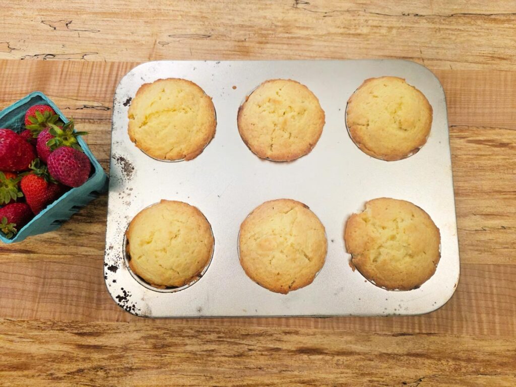 Individual strawberry shortcakes in a large muffin tin.