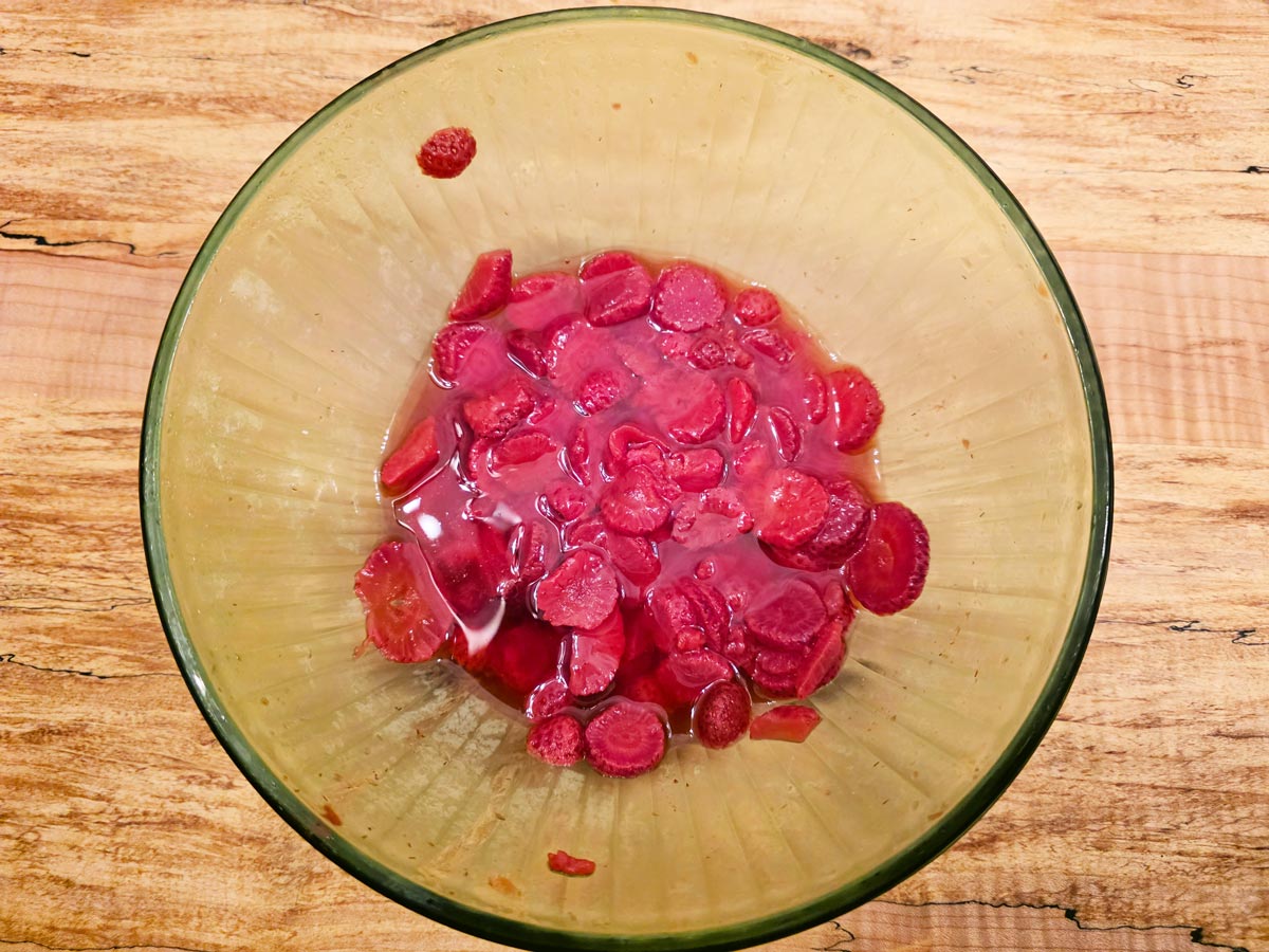 Strawberries being macerated in a bowl.