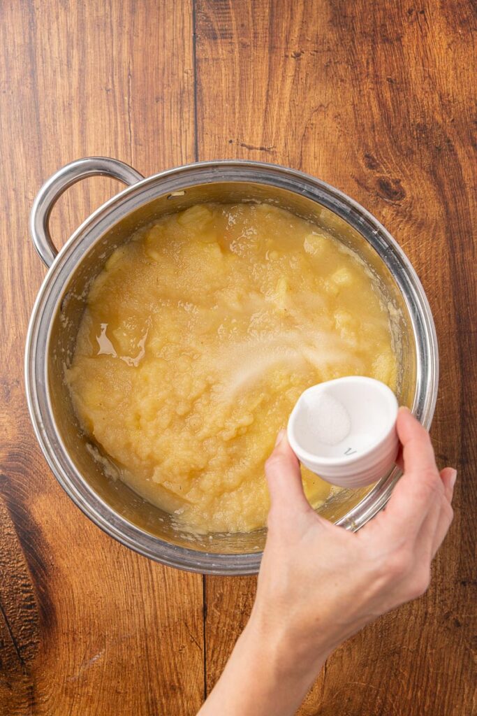 Adding sugar to applesauce.