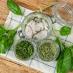 Basil salt three ways in jars on a counter.