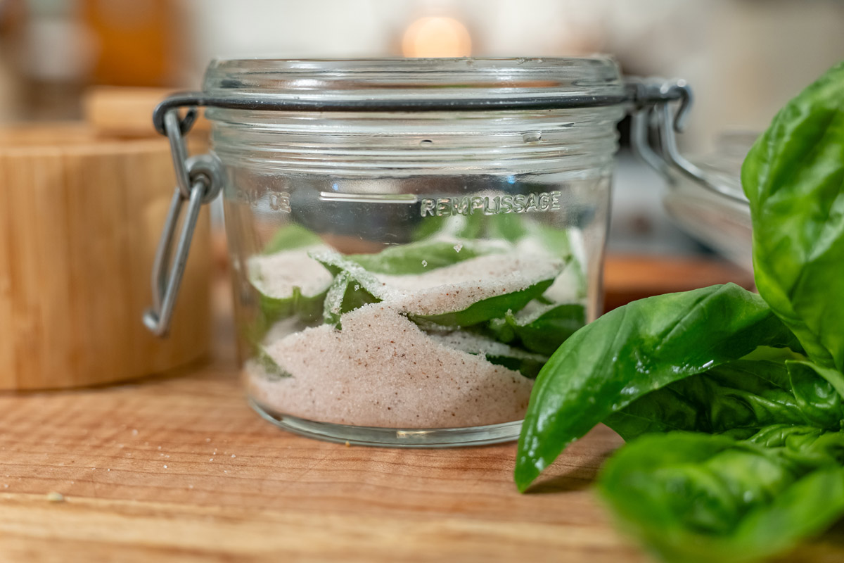 Basil layered in salt in a jar.