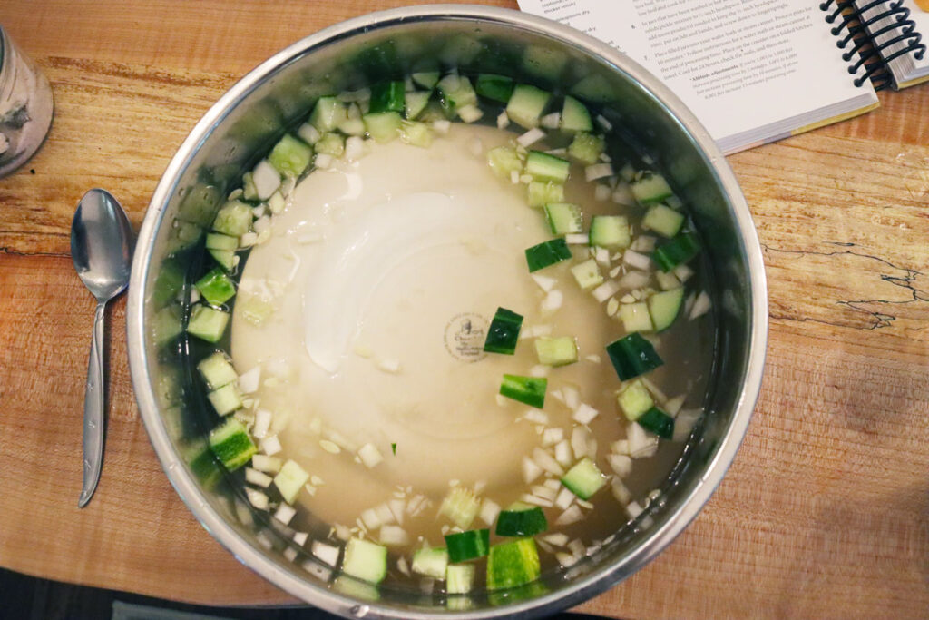 Cucumbers and onions soaking in a pot of water.