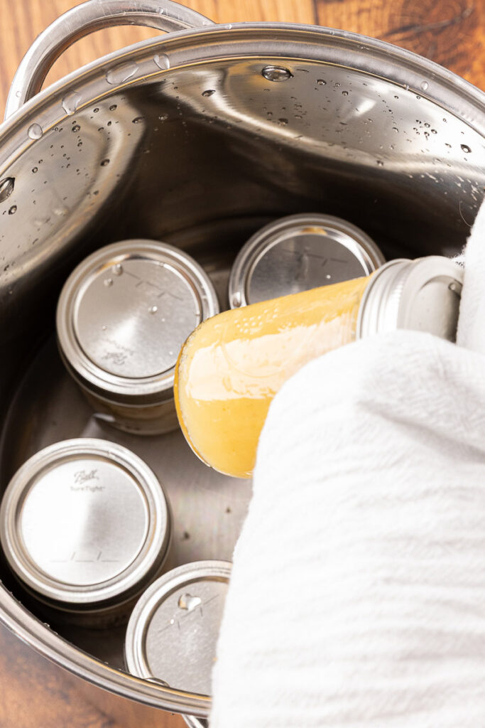 Hot applesauce being taken out of a water bath canner.