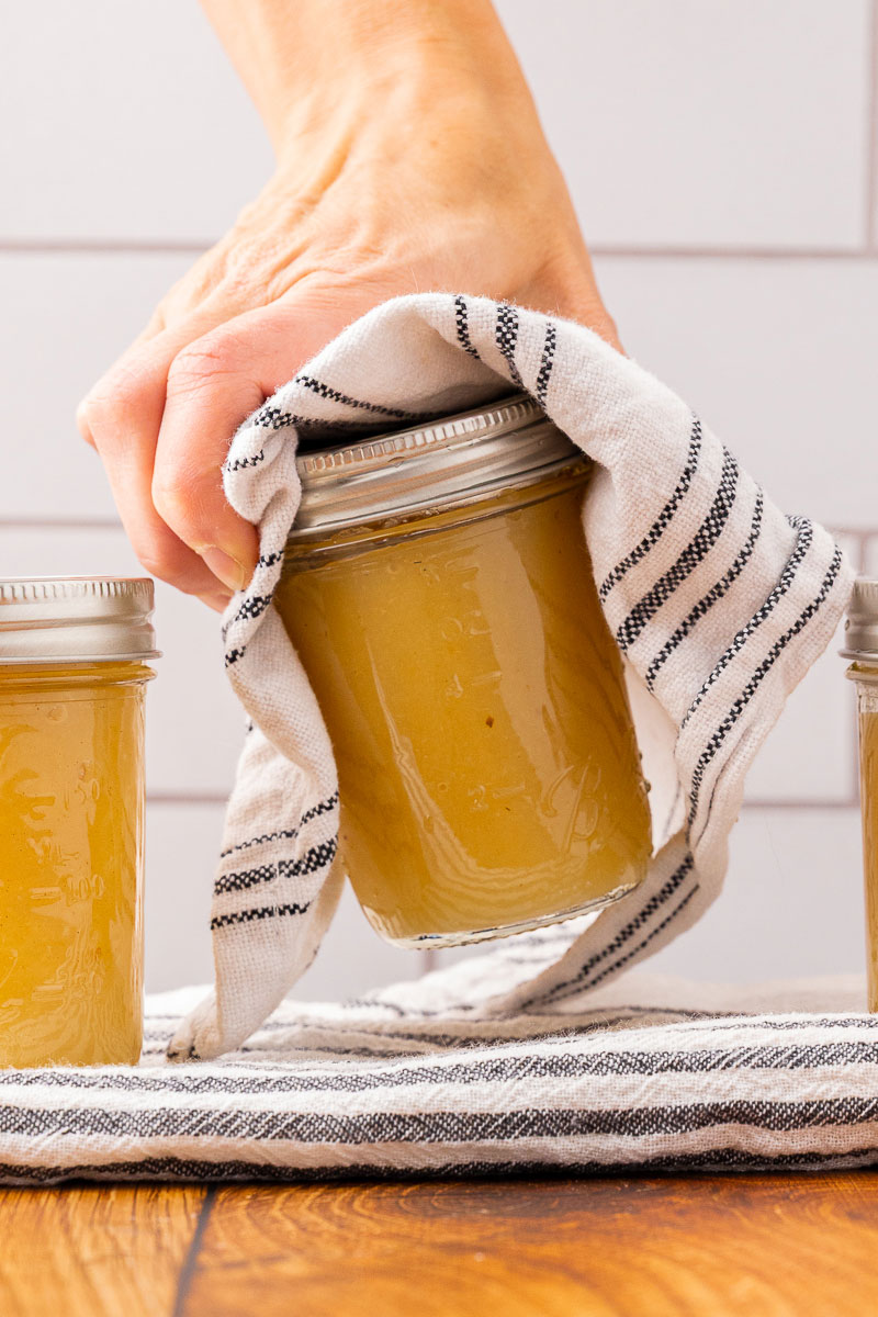 Hot applesauce being placed on a towel-lined counter.