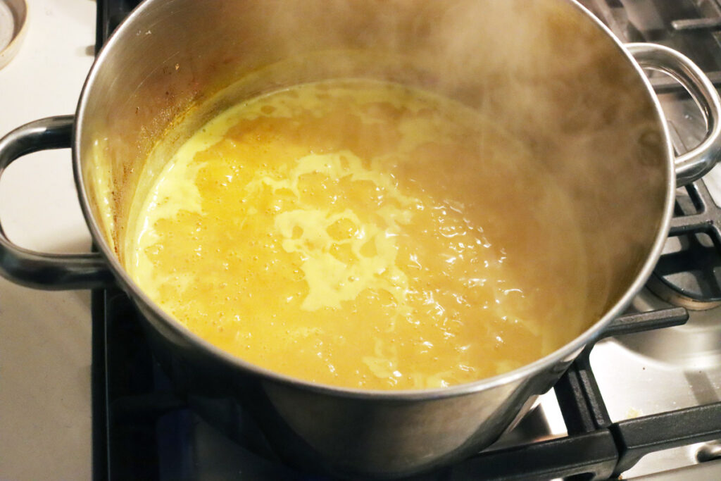Mustard pickles brine being boiled in a pot.