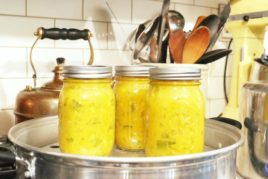 Jars of mustard pickles in a water bath steam canner.