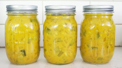 Jars of mustard pickles sitting on a counter.