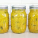 Jars of mustard pickles sitting on a counter.