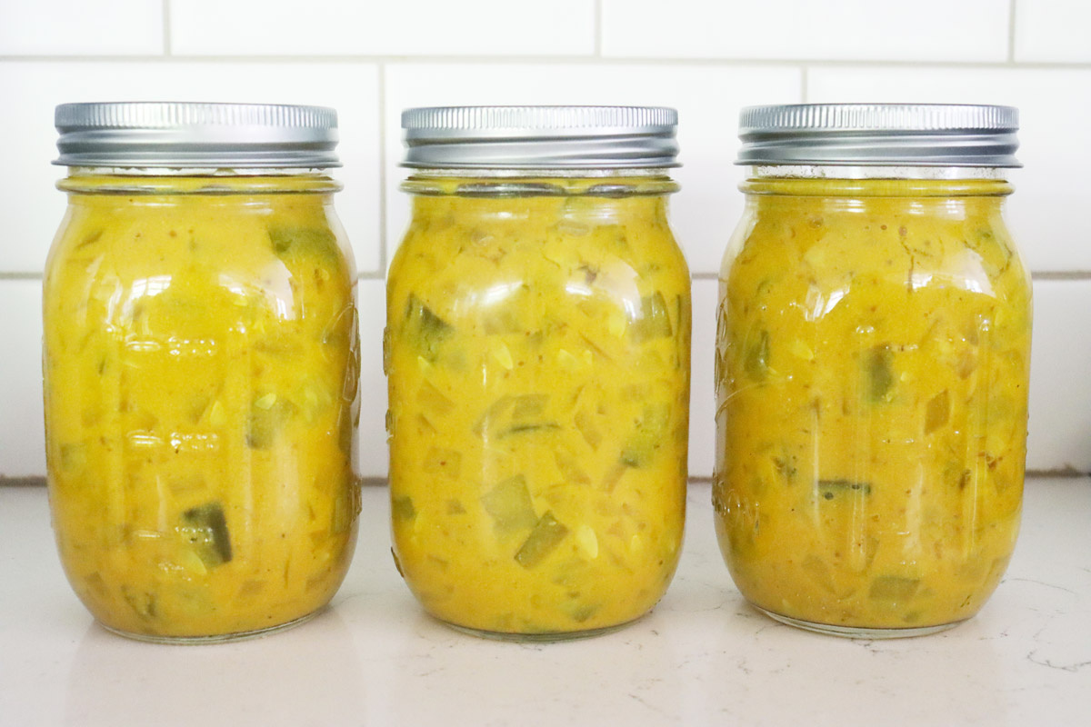 Jars of mustard pickles sitting on a counter.