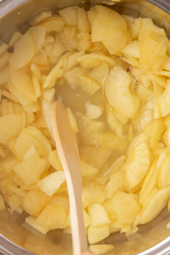 Apples cooking down in a large pot.