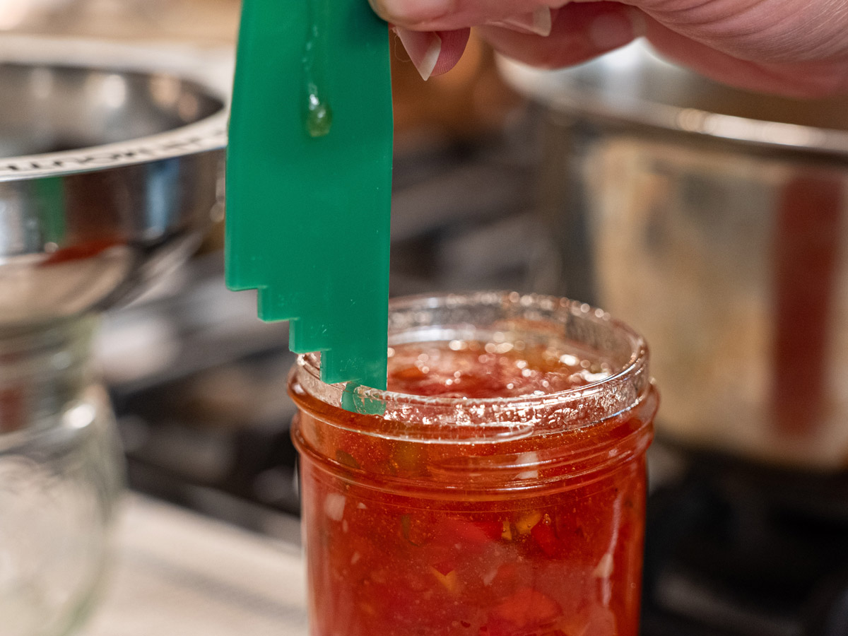 Measuring the headspace for the jar of red pepper jelly.