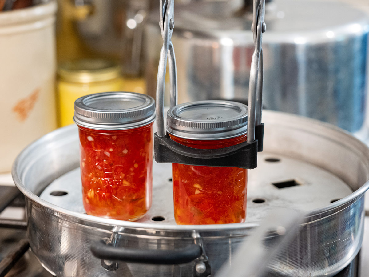 Jars of red pepper jelly going onto a steam canner.