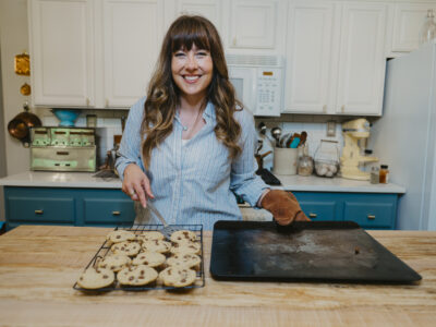 A woman in the kitchen baking cookies.