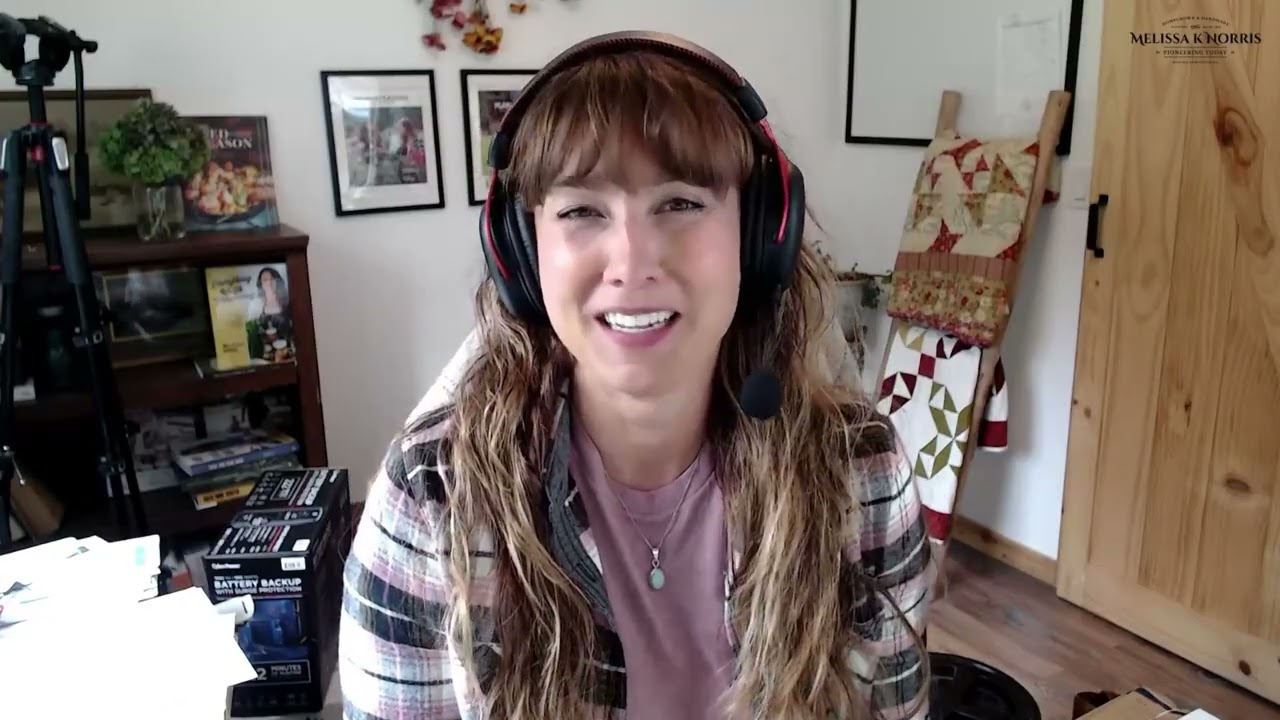 A woman at a computer with headphones on.