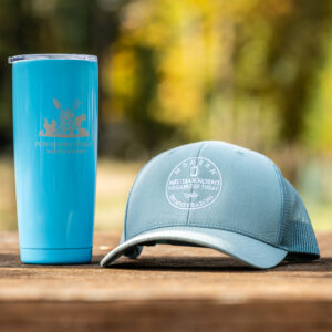 Trucker hat and stainless steel Pioneering Today Tumbler on a table