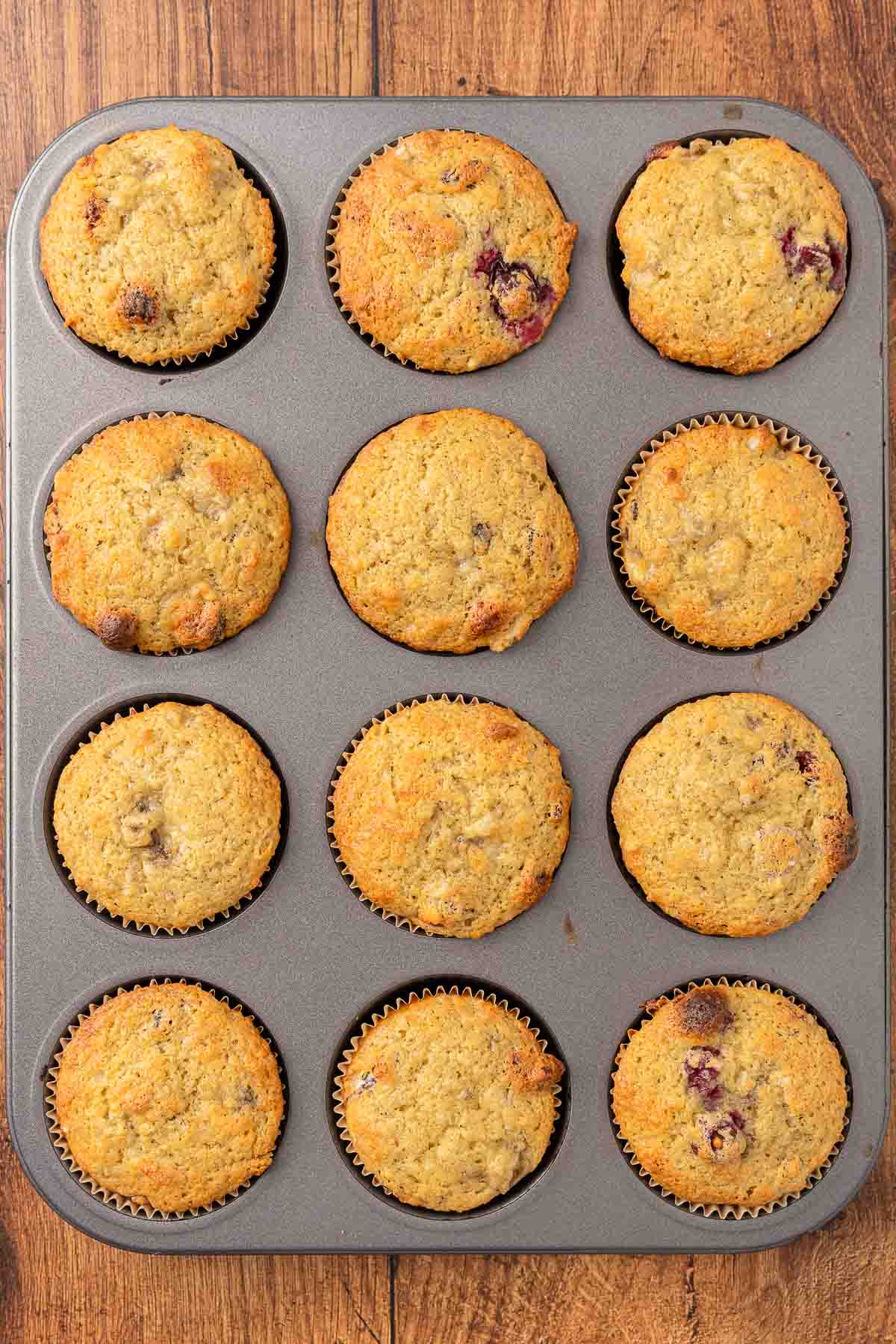 Baked cranberry muffins in a muffin tin.