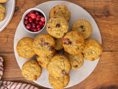 Cranberry muffins stacked on a white plate.