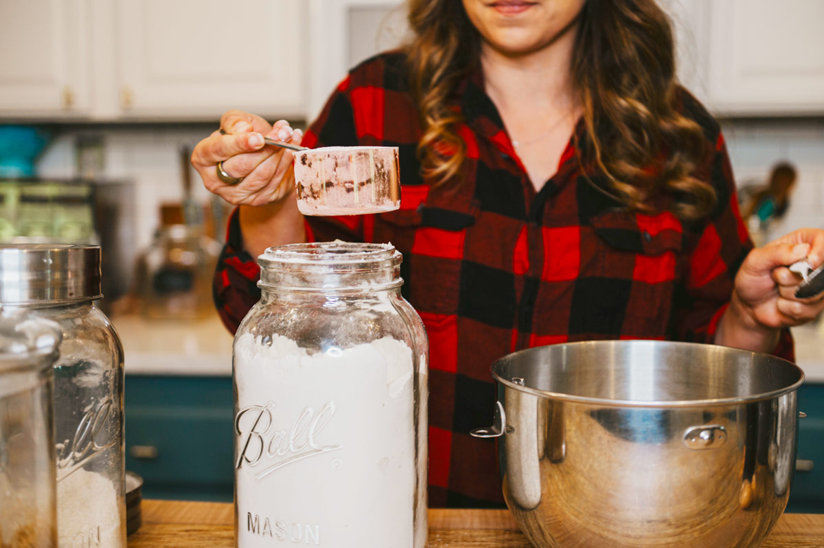 A woman measuring flour.