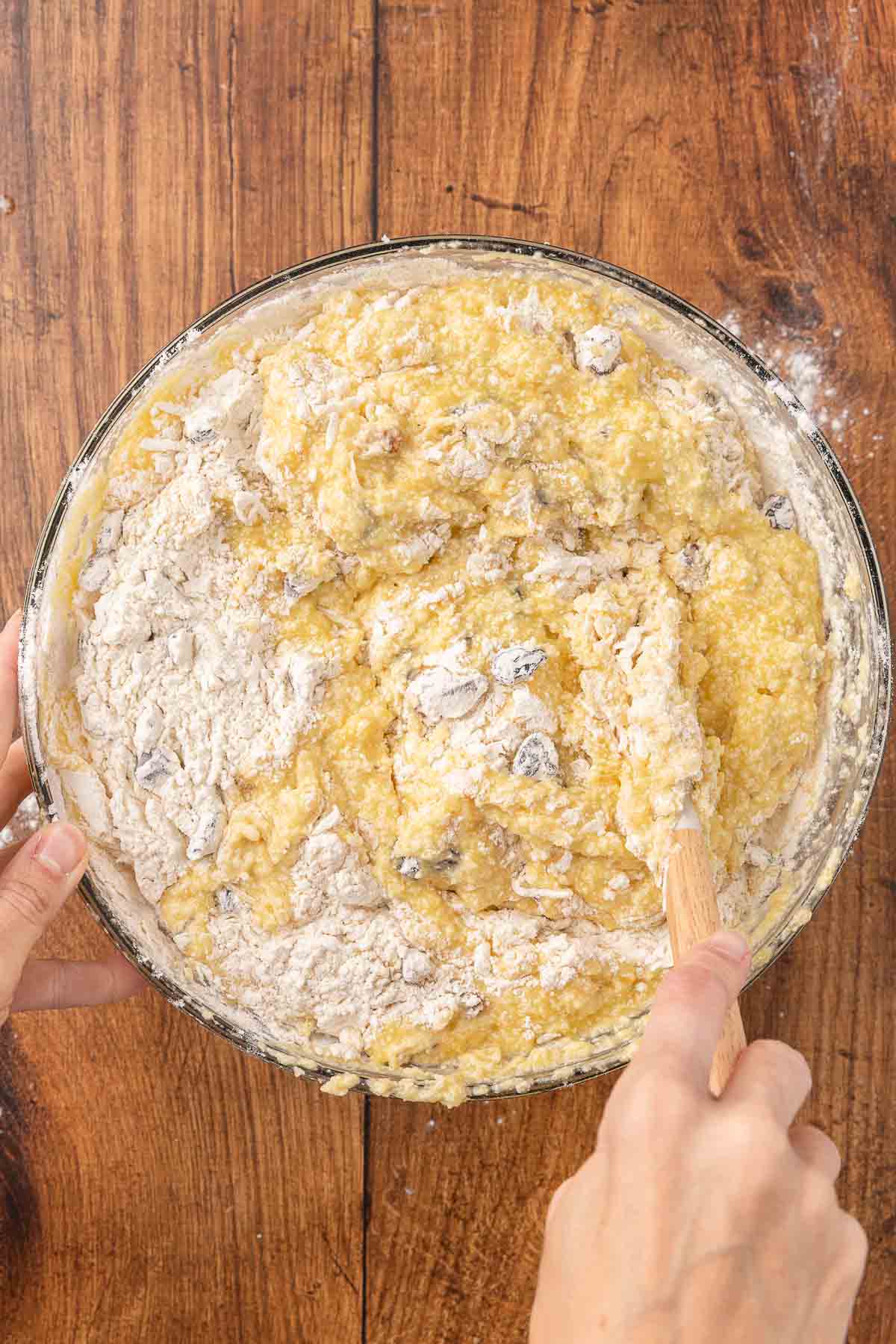 Stirring ingredients for cranberry muffins together in a bowl.