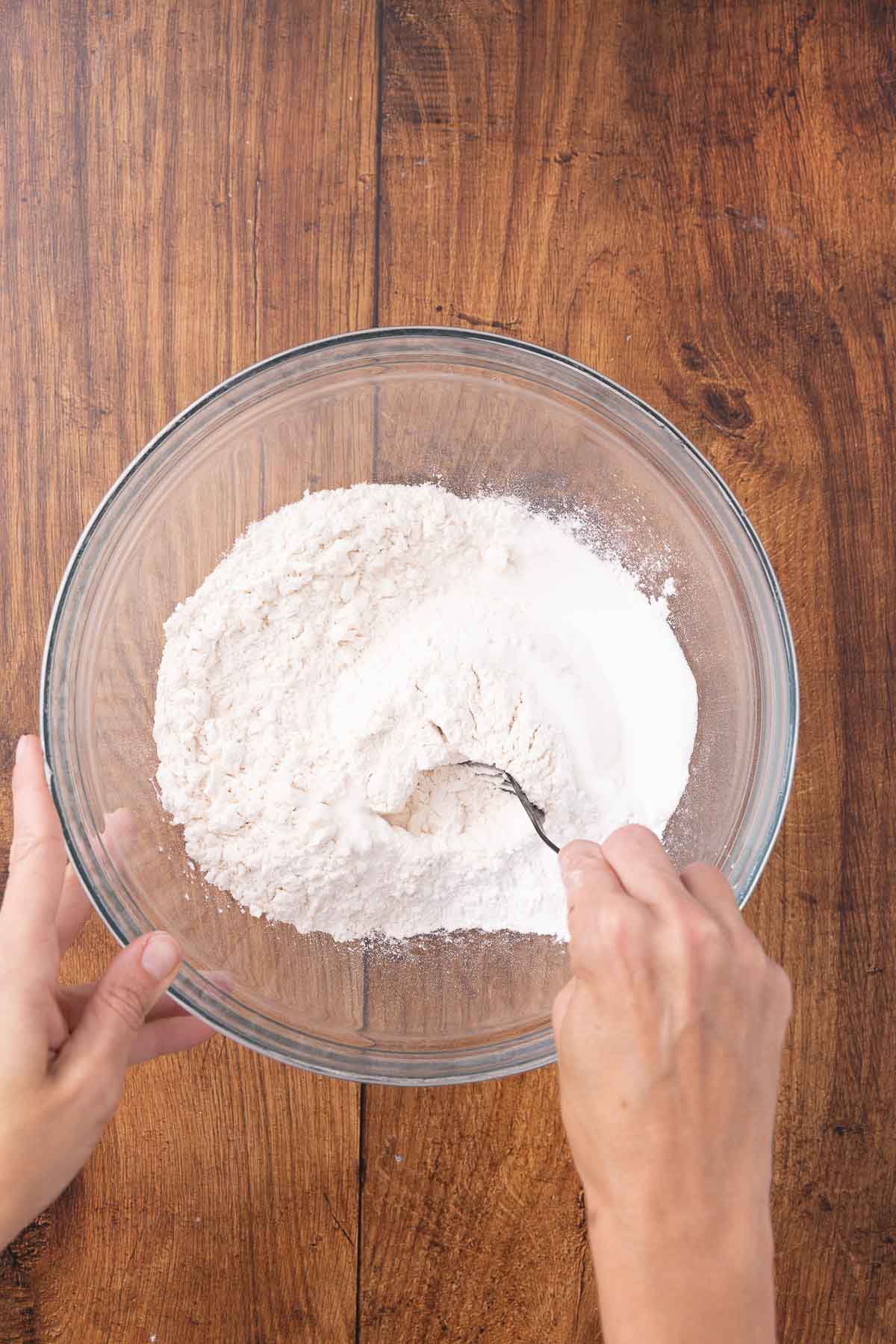 Mixing together flour and salt in a bowl.