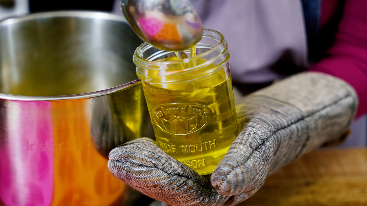 Liquid tallow being ladled into a jar.