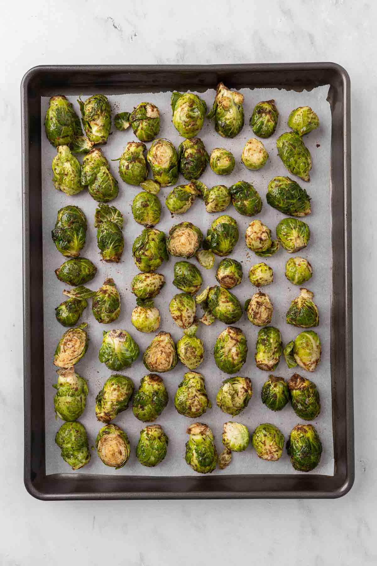 Unbaked Honey Balsamic Brussel Sprouts on a white plate.