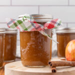 A jar of apple butter with a ribbon tied around it.