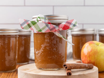 A jar of apple butter with a ribbon tied around it.