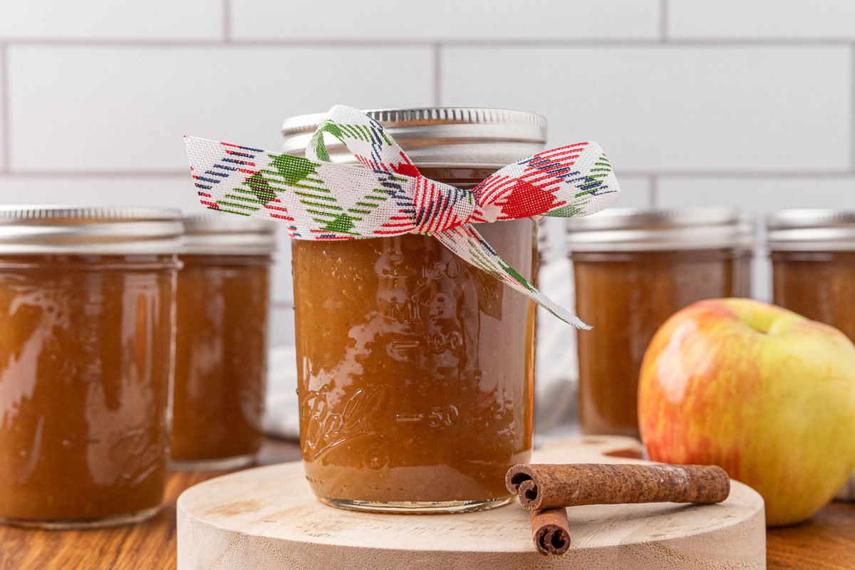 A jar of apple butter with a ribbon tied around it.