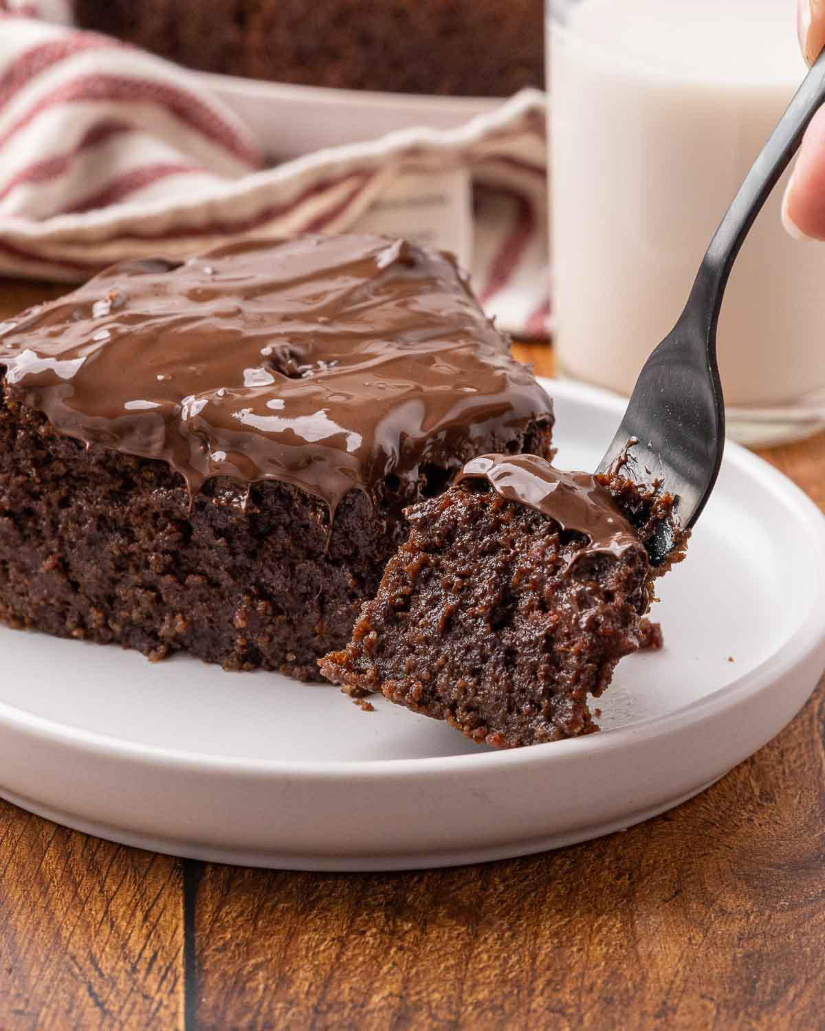 A slice of chocolate beet cake with a bite on a fork to show texture.