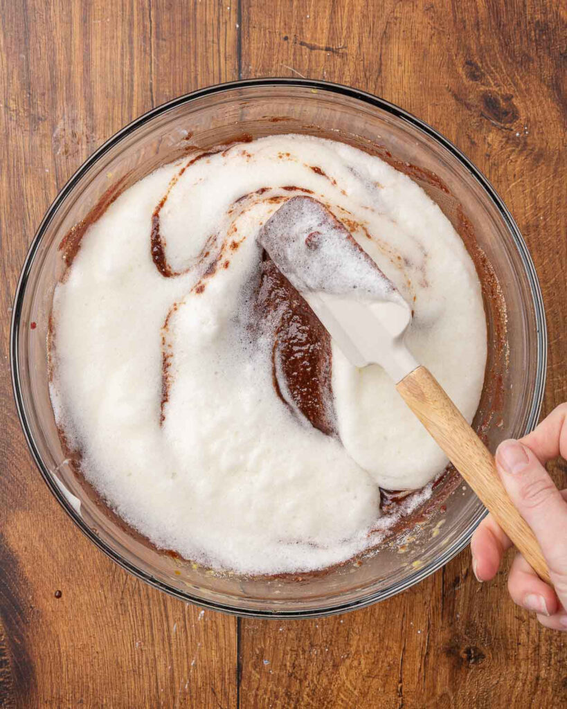 A spatula folding egg whites into the chocolate mixture.