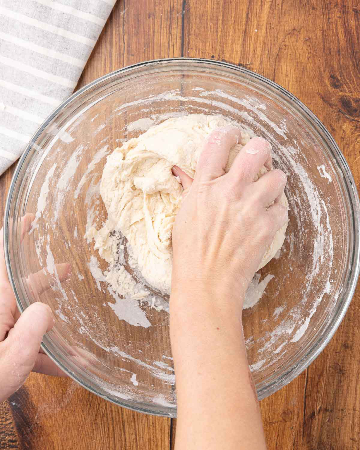 A woman hand mixing sourdough sandwich bread dough.
