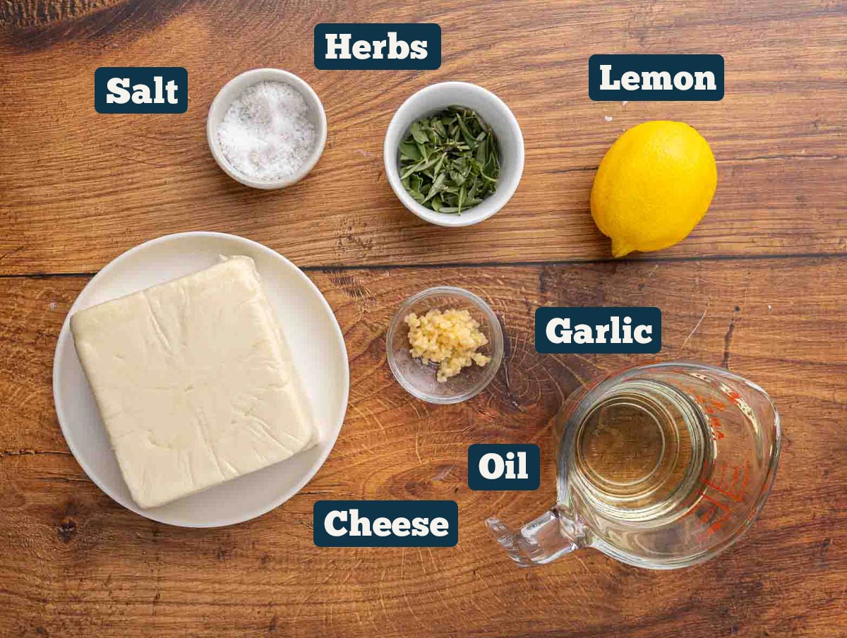 Marinated mozzarella ball ingredients: Mozzarella, salt, herbs, lemon, garlic, and oil.