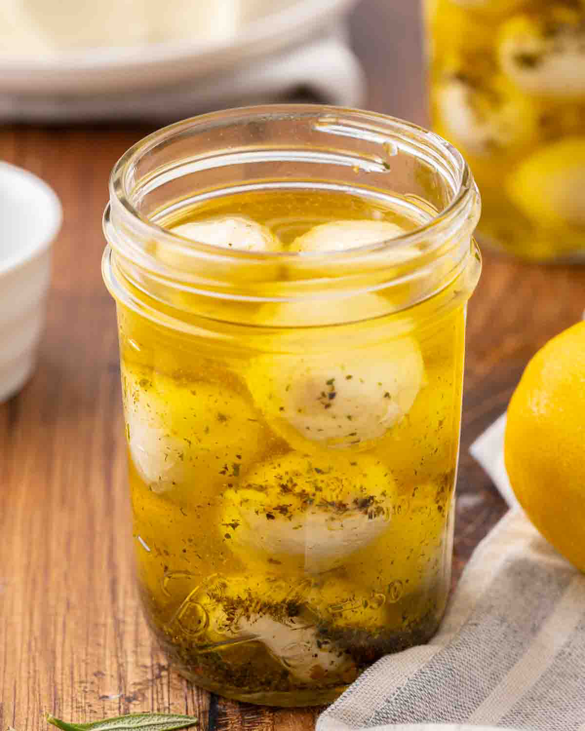 An opened jar of marinated mozzarella balls.
