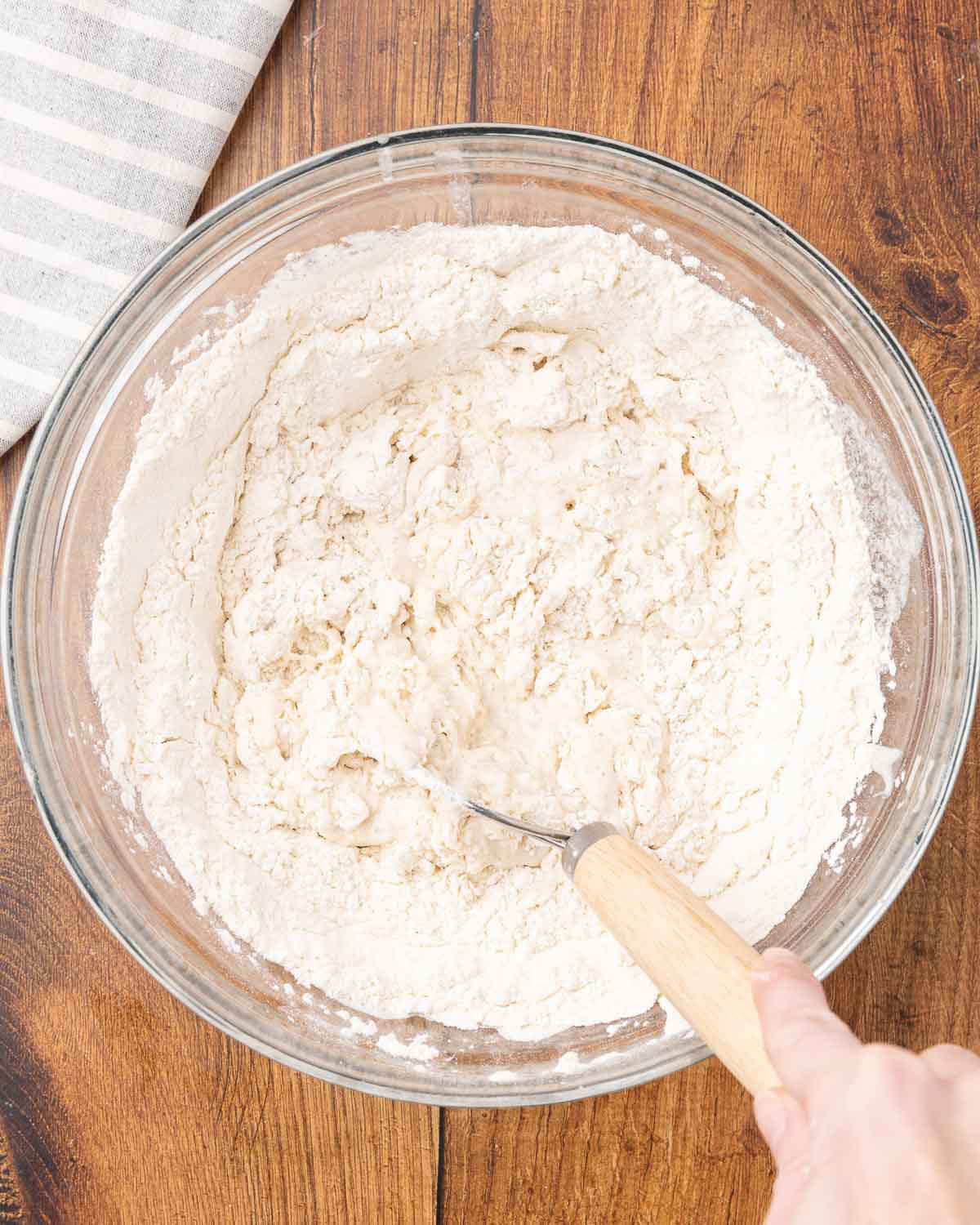 Sandwich bread dough being mixed in a bowl.