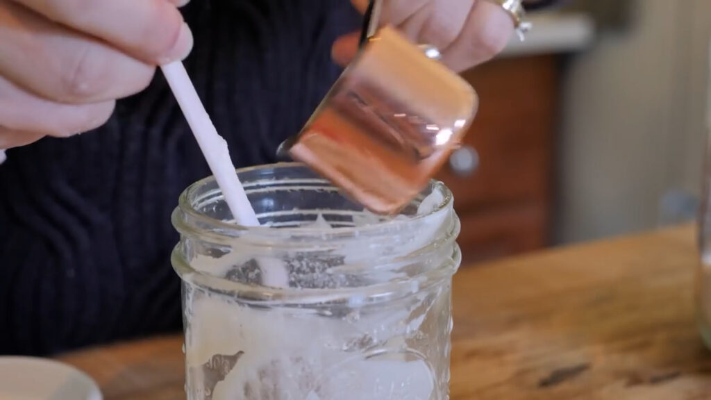 Feeding the sourdough starter with fresh flour and water.