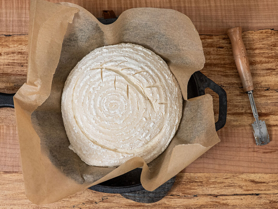 A sourdough boule that's been scored and ready to bake.