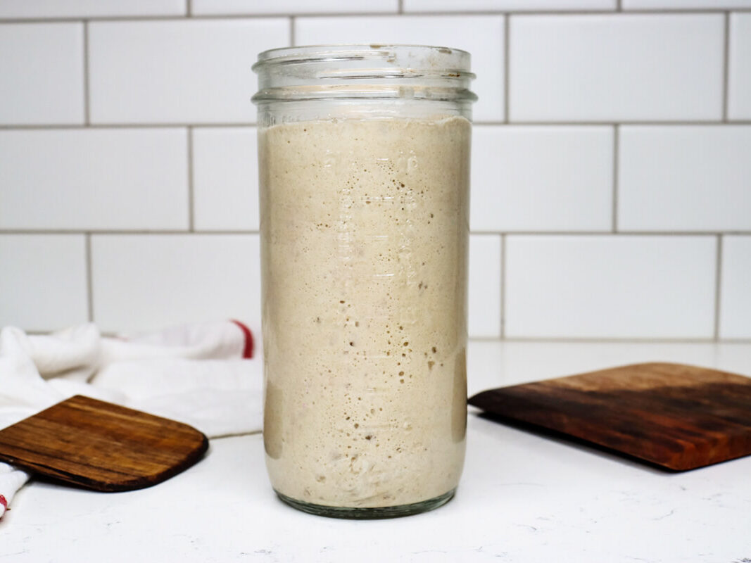 Sourdough starter in a jar on a counter.