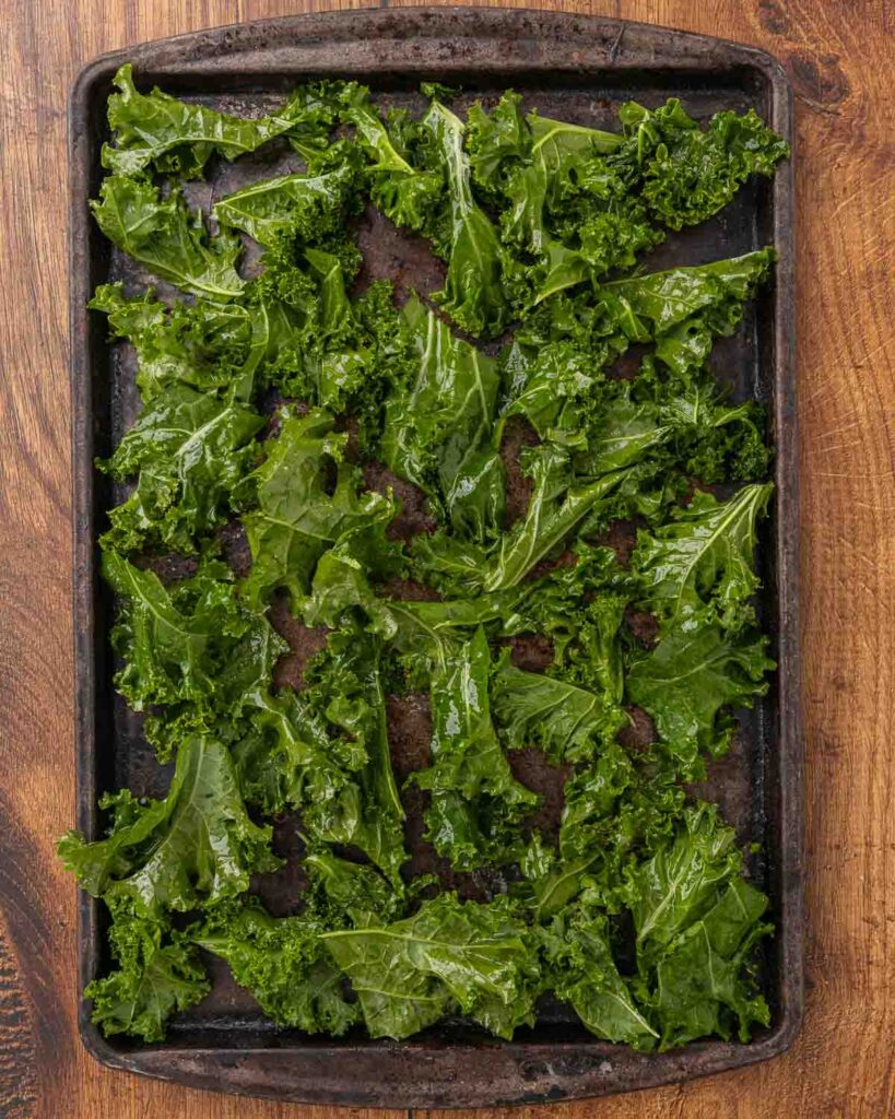 Fresh kale arranged on a baking sheet ready for the oven.