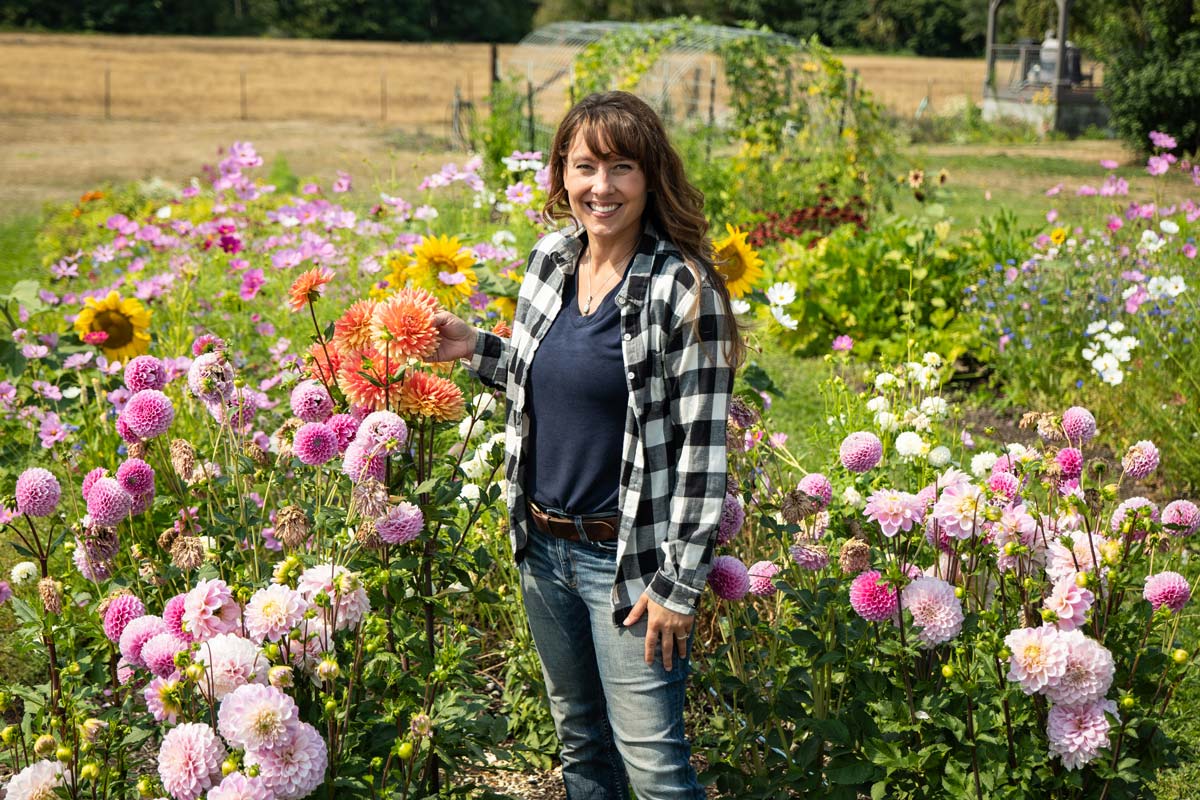 A woman standing in a flower garden.