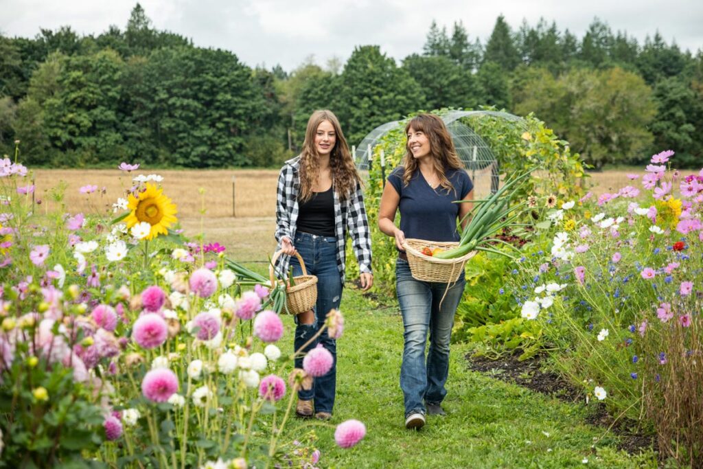 A woman and her daughter walking through a garden.