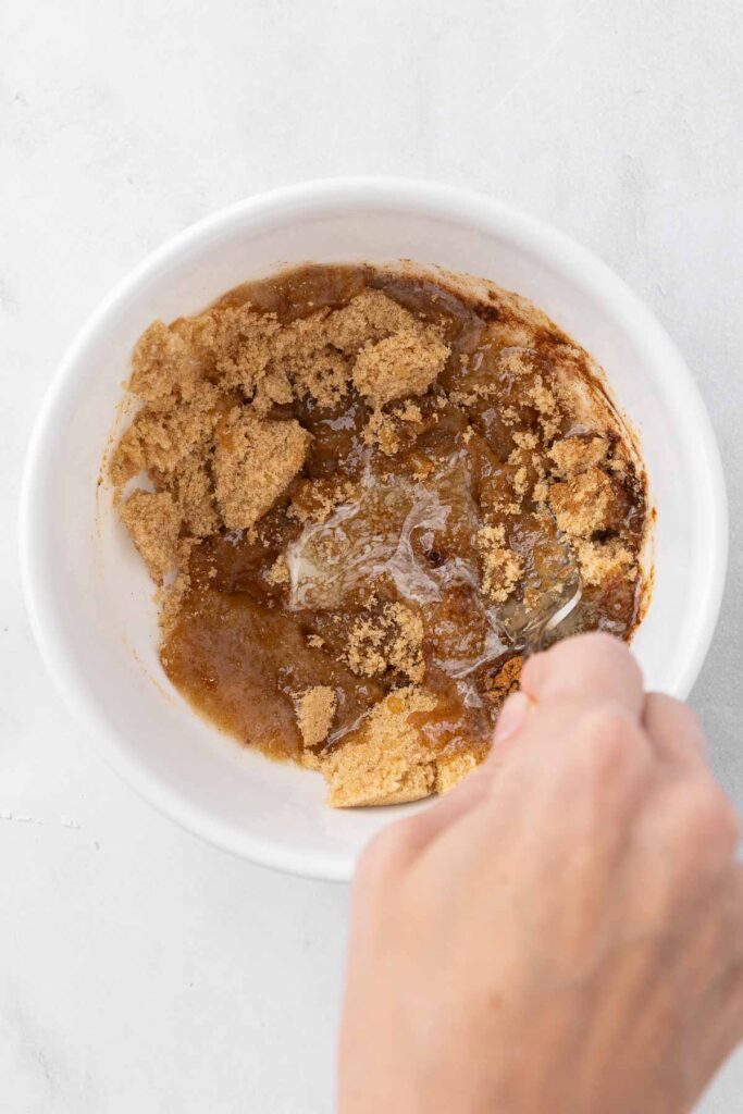 A fork blending brown sugar topping for pineapple upside down cake.