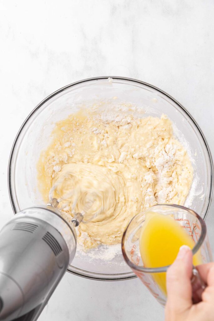 Adding pineapple juice pineapple upside down cake batter.