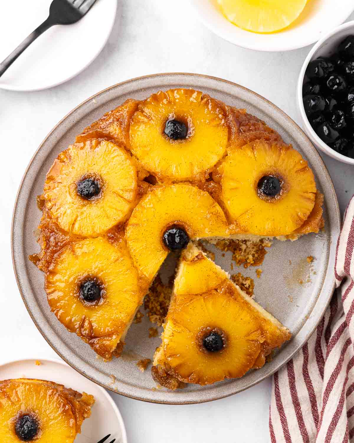Bird's eye view of a pineapple upside down cake with a slice removed.