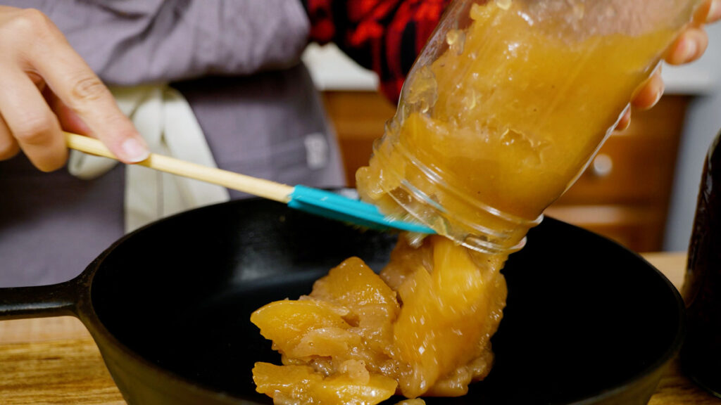 Dumping apple pie filling from a jar.