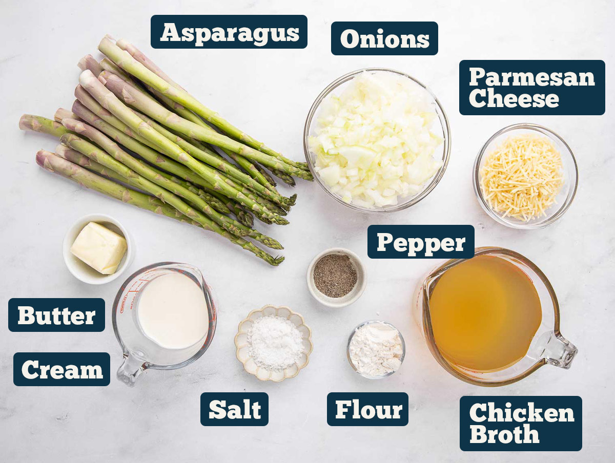 Creamy asparagus soup ingredients: asparagus, onions, Parmesan cheese, pepper, butter, cream, salt, flour, and chicken broth.