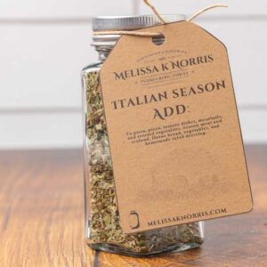 A jar filled with DIY Italian seasoning mix, and labeled with a tag.