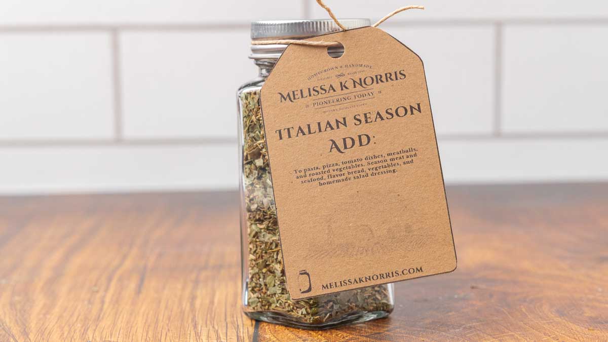 A jar filled with DIY Italian seasoning mix, and labeled with a tag.