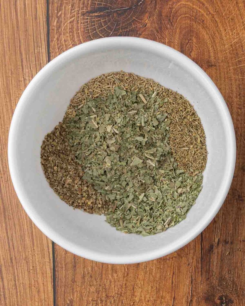 DIY Italian seasoning ingredients layered in a small bowl.