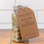 A jar filled with DIY ranch seasoning mix, and labeled with a tag.